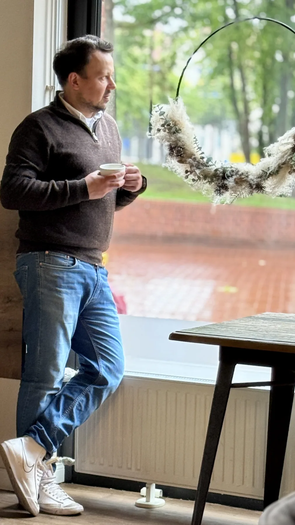 Igor Mamanow mit einer Tasse am Fenster des Hildes